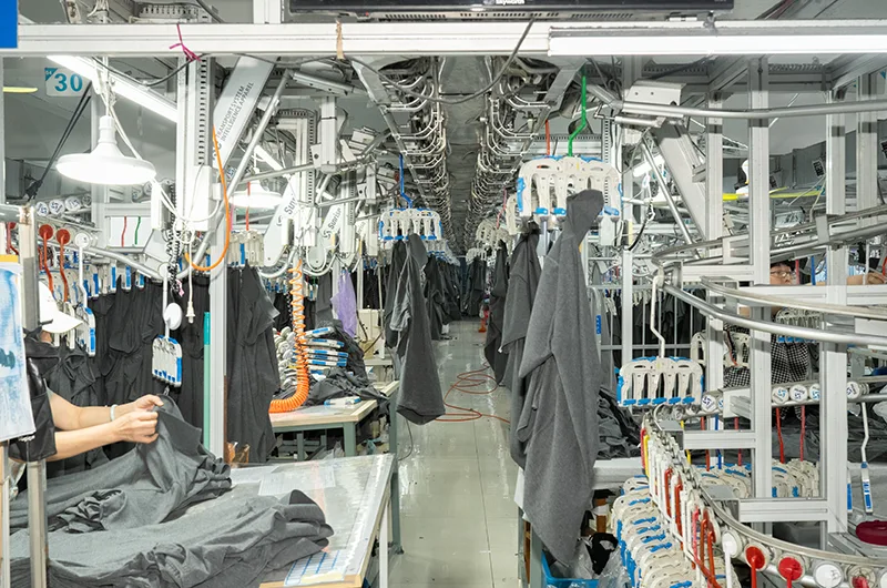 Skilled worker sewing garments on the apparel assembly line